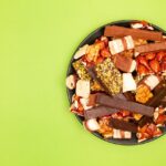 Barrette energetiche fatte in casa senza zuccheri, ingredienti naturali su un tavolo di legno.