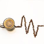 Tazza di caffè fumante su un tavolo, simbolo della sua influenza sul colesterolo.