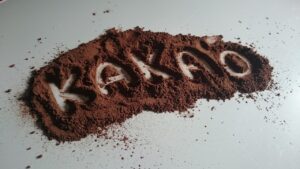 Semi di cacao amaro su sfondo bianco, simbolo dei benefici per l'umore.