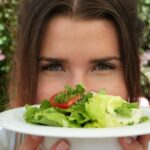 Persona che pratica il mindful eating, gustando un pasto sano con attenzione e serenità.