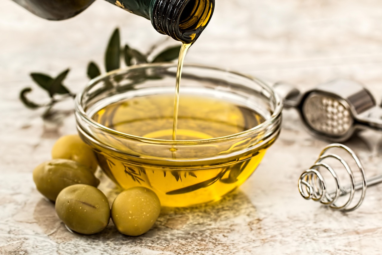 Olio d'oliva versato in un cucchiaio, simbolo di salute e benessere a digiuno.