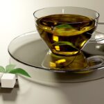 Tazza di tè verde fumante su tavolo, simbolo dei benefici quotidiani per la salute.